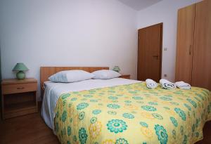 ein Schlafzimmer mit einem Bett mit zwei Schuhen drauf in der Unterkunft Apartments Lucija in Sukošan