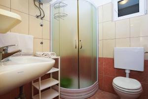 ein Badezimmer mit Dusche, Toilette und Waschbecken in der Unterkunft Apartments Lucija in Sukošan