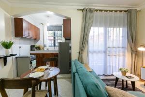 a living room and kitchen with a couch and a table at Comfortable and sophisticated Apartment in Kampala