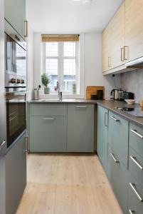 eine Küche mit blauen Schränken und Holzböden in der Unterkunft Historic Bergen house in the middle of the city center in Bergen