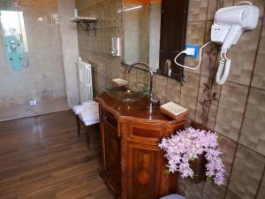 a bathroom with a sink and a mirror and flowers at B&B Santa Vittoria in Monteleone Sabino +44 photos