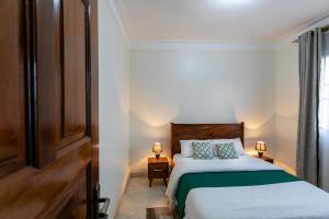 a bedroom with a bed and two lamps and a window at Comfortable and sophisticated Apartment in Kampala