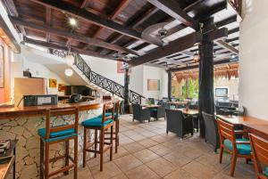 a restaurant with a bar and tables and chairs at Hotel Riviera Del Sol in Playa del Carmen