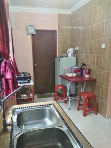 a kitchen with a sink and a table at Z&R HOMESTAY in Kota Bharu