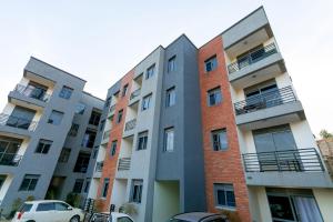 an apartment building with cars parked in front of it at Comfortable and sophisticated Apartment in Kampala