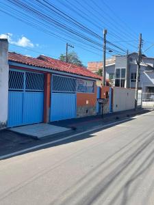 an empty street next to a building with blue doors at Kitnet Adorável na sedede Aracruz ES 1KM do centro individual wifi cozinha equipada in Aracruz