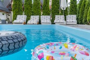 a pool with chairs and a ball in the water at Willa Dream II Resort & Spa in Krynica Zdrój