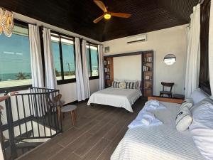 a bedroom with two beds and a ceiling fan at 360 Suites - Seaside 6Bedroom Retreat in Caye Caulker
