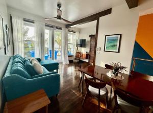 a living room with a blue couch and a table at 360 Suites - Seaside 6Bedroom Retreat in Caye Caulker