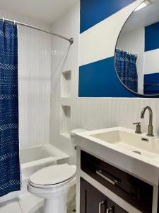 a bathroom with a toilet and a sink and a mirror at 360 Suites - Seaside 6Bedroom Retreat in Caye Caulker