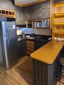 a kitchen with a stainless steel refrigerator and a counter at Flat Exclusivo Studio Cuiabá 1604 in Cuiabá
