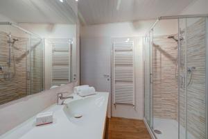 un baño con lavabo y ducha en Vicky Loft Morgnaga - Happy Rentals, en Gardone Riviera