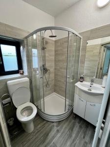 Un baño con ducha, inodoro y lavabo. en Centrum, en Odorheiu Secuiesc