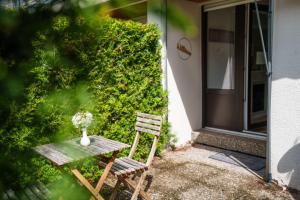 ein Holztisch und zwei Stühle vor einem Haus in der Unterkunft Entspannung mitten im Schwarzwald mit Infrarotsauna und Massagesessel in Schönwald