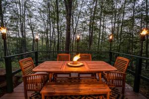a wooden table with chairs and a candle on a deck at Finley Lodge in Cooks Crossing