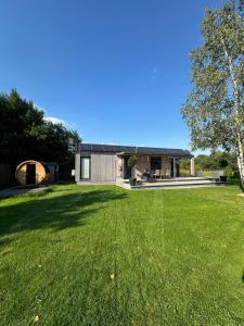 a house with a large lawn in front of it at Domek Veli Stawinoga in Stawinoga