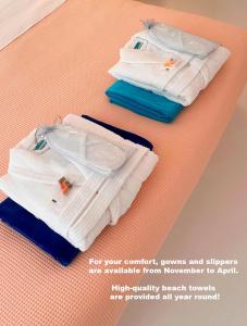 Zwei weiße Handtücher liegen auf einem Tisch. in der Unterkunft Sunset Deluxe Villa and Studios in Paphos City