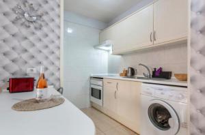 une cuisine avec une machine à laver et un évier dans l'établissement Nos lo merecemos, à Puerto de Santiago