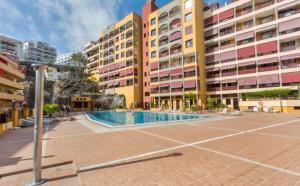 a large building with a swimming pool in front of it at Nos lo merecemos in Puerto de Santiago