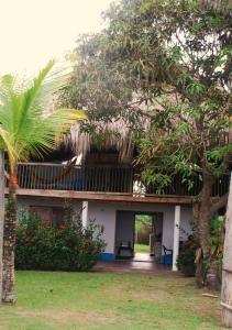 a house with a balcony and a tree at La Creciente donde el tiempo se detiene in Necoclí