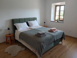 a bedroom with a bed with two towels on it at Domačija Blaževc in Žiri