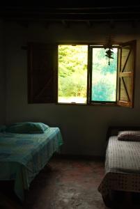 a room with two beds and a window at La Creciente donde el tiempo se detiene in Necoclí