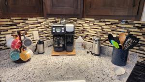 a kitchen counter with a coffee maker and utensils at Parkside Cabins in West Yellowstone