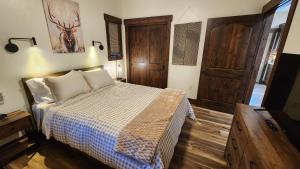 a bedroom with a bed and a wooden floor at Parkside Cabins in West Yellowstone
