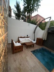 a patio with couches and a table and a pool at Royal Arabian Night in Marrakech