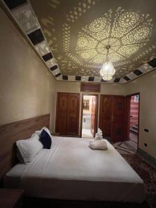 a bedroom with a large bed with a ceiling at Royal Arabian Night in Marrakech