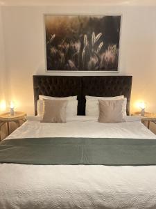 a bedroom with a large bed with a painting on the wall at Bright & Stylish 2 bed Flat, Great Location in Southampton