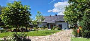 a house with a garden in front of it at Osada Ostrowsko in Uniejow