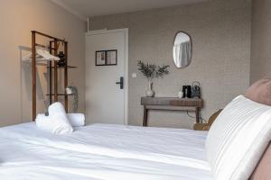ein Schlafzimmer mit einem weißen Bett und einem Spiegel in der Unterkunft University Tilburg Affordable Room Walk In Nature in Tilburg