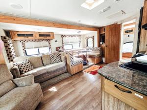 an rv living room with a couch and a table at Nicevilles' Hidden Backyard Camper in Niceville