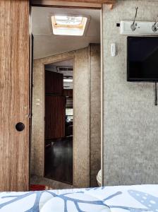 a room with a bed and a flat screen tv at Nicevilles' Hidden Backyard Camper in Niceville