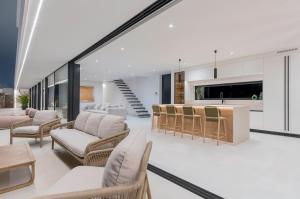 Una sala de estar abierta con sillas y una cocina. en Villa White Lava by Aura Collection, en Lajares