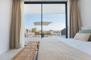 Un dormitorio con una cama y una gran ventana de cristal. en Villa White Lava by Aura Collection, en Lajares 59 fotos más