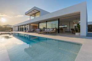 a house with a swimming pool in front of it at Villa White Lava by Aura Collection in Lajares
