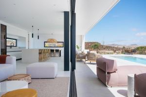 an open kitchen and living room with a swimming pool at Villa White Lava by Aura Collection in Lajares