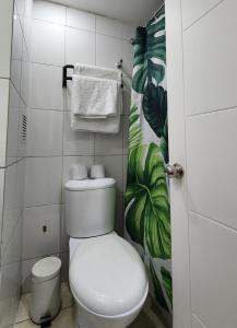 a bathroom with a white toilet and towels at Familiar en el centro de Santiago 16 B in Santiago +8 photos
