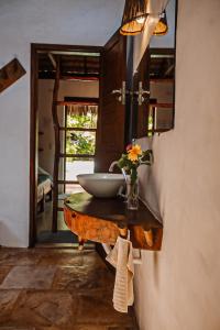 a bathroom with a bowl sink on a wooden table at Pousada Castelo Do Vento in Prea