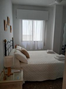 Un dormitorio con una cama grande con ventana. en Apartamento Huelva Centro, en Huelva 15 fotos más