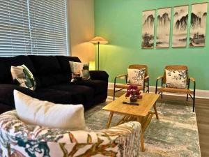 a living room with a black couch and two chairs at Well-Equipped 2BR Unit with Parking - GBay 301 in Evanston