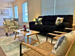 a living room with a black couch and a table at Well-Equipped 2BR Unit with Parking - GBay 301 in Evanston