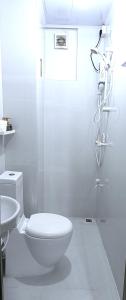 a white bathroom with a toilet and a shower at AlTyn Stay in Male City