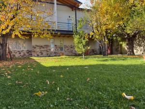 a house with a yard with leaves in the grass at La Calala Aparts in Esquel