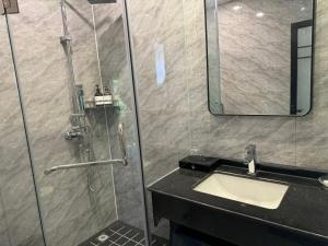 a bathroom with a shower with a sink and a mirror at 兰亭山庄 in Kaôh Rŭng (5)