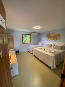 a hotel room with two beds and a window at Pousada Céu da Chapadha in Mucugê