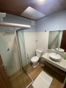 a bathroom with a toilet and a sink and a shower at Pousada Céu da Chapadha in Mucugê
