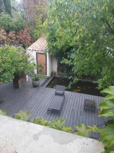 a wooden deck with two chairs and a house at Chambre avec vue sur jardin et piscine in Les Angles Gard